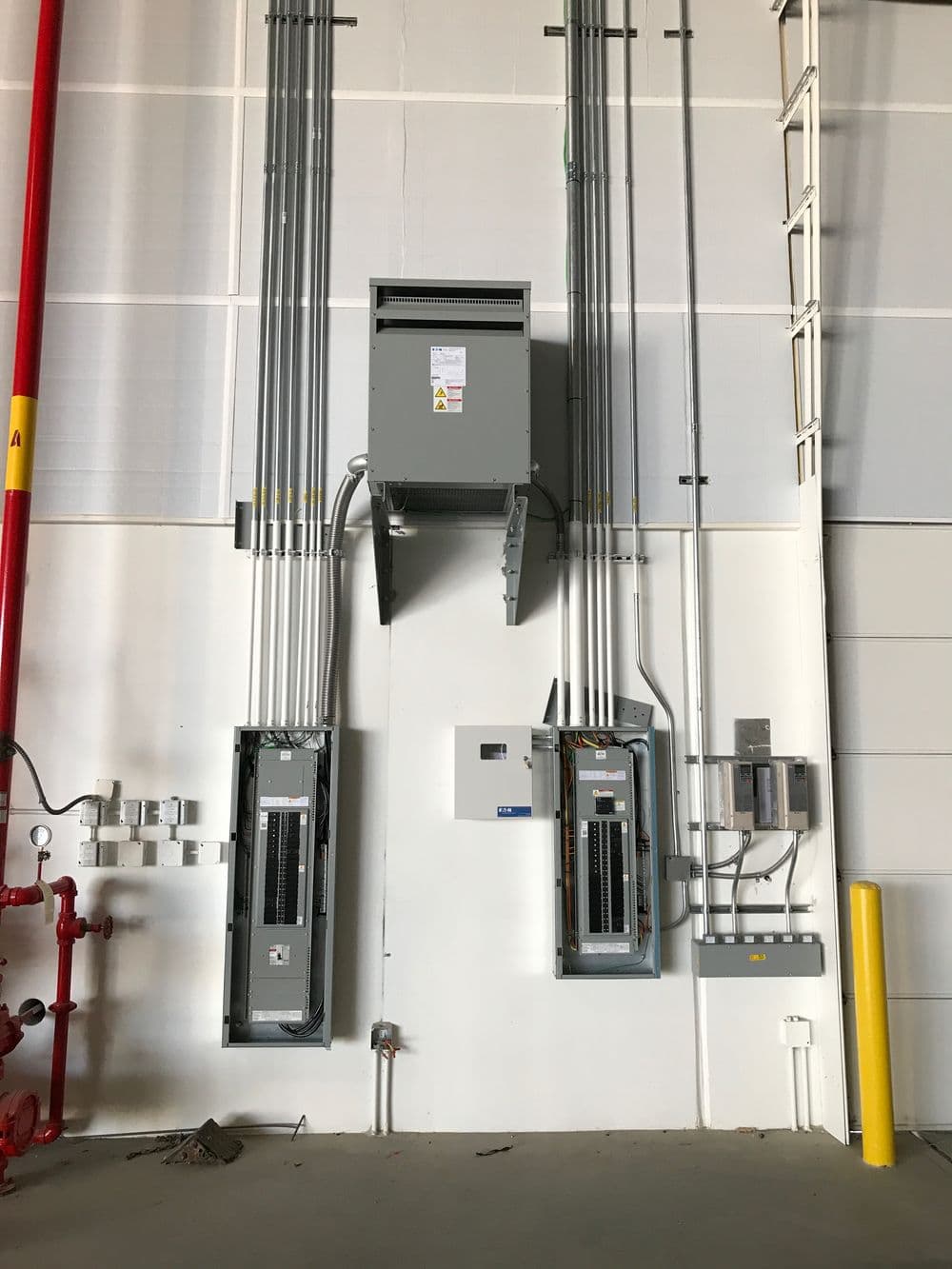 Electrical panel installation with circuit breakers and wiring in a commercial setting.