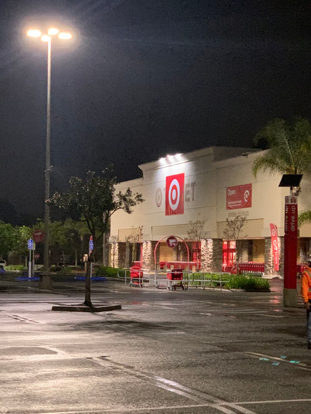 Target store exterior at night, illuminated by streetlights, with shopping carts outside.
